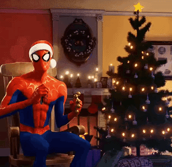 A Spider Man Wearing A Santa Hat Is Sitting In A Chair In Front Of A Christmas Tree GIF