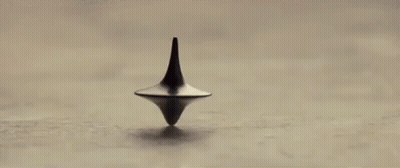 A Spinning Top Is Spinning On A Table In A Black And White Photo . GIF