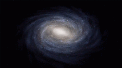A Spiral Galaxy In The Middle Of A Dark Blue Background GIF