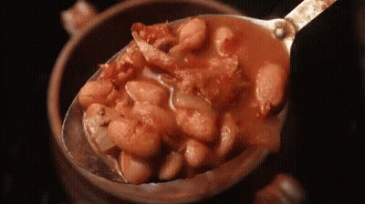 A Spoon Is Scooping Beans Out Of A Bowl . GIF