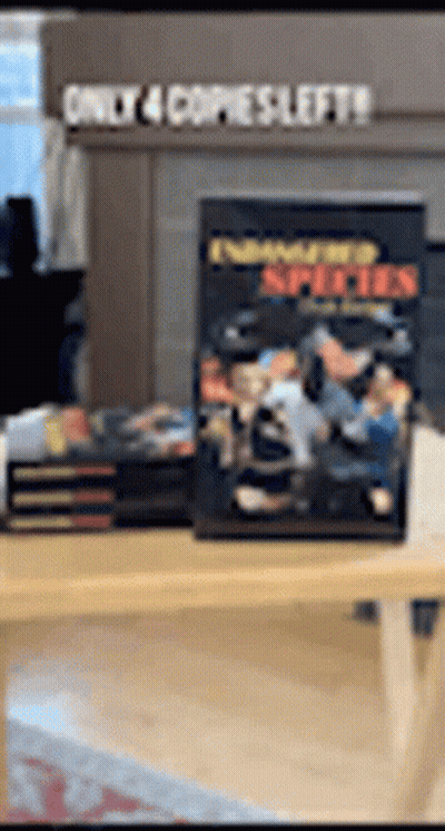 A Stack Of Books Sitting On Top Of A Wooden Table With A Sign That Says Only 4 Copies Left . GIF