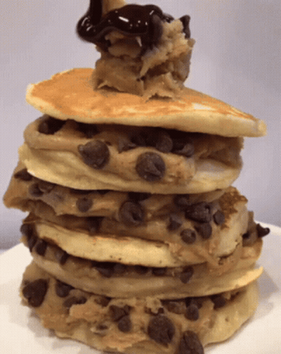 A Stack Of Cookies And Cream Pancakes With Chocolate Sauce On Top GIF