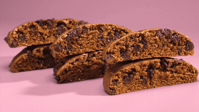 A Stack Of Cookies With Chocolate Chips On A Pink Surface GIF