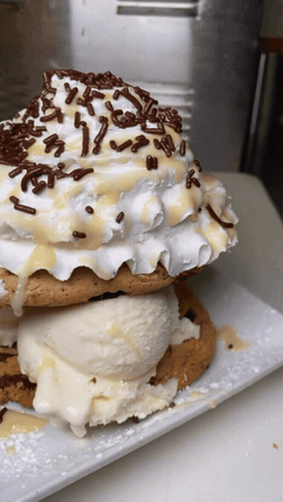 A Stack Of Cookies With Ice Cream And Whipped Cream GIF