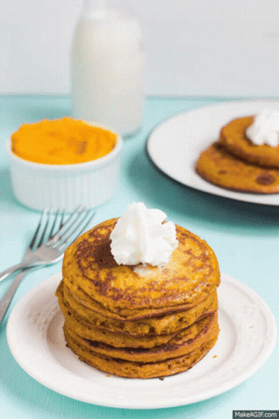 A Stack Of Pancakes On A Plate With Whipped Cream On Top GIF