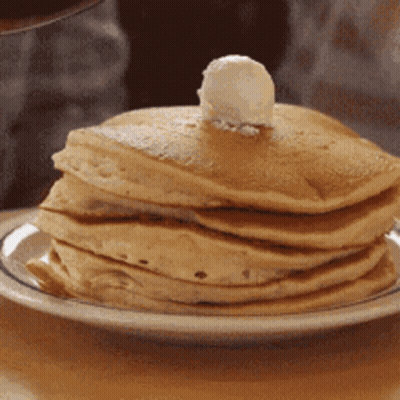 A Stack Of Pancakes With Butter On Top On A White Plate GIF