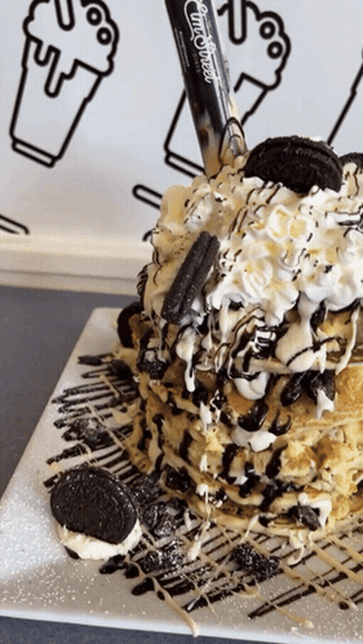 A Stack Of Pancakes With Oreos And Whipped Cream On Top GIF