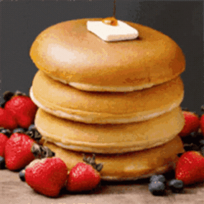 A Stack Of Pancakes With Strawberries And Blueberries On Top GIF