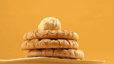 A Stack Of Peanut Butter Cookies On A White Plate With A Tong GIF