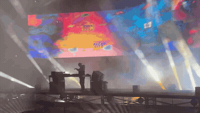 A Stage With A Large Screen Behind It That Says Dread City GIF