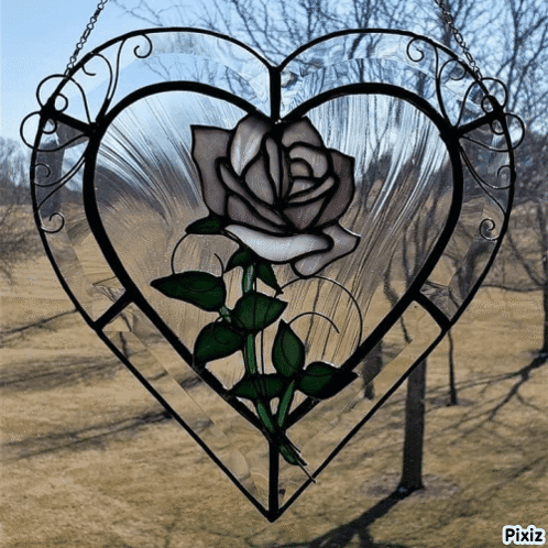 A Stained Glass Heart With A White Rose In The Center GIF