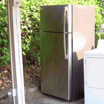 A Stainless Steel Refrigerator Is Sitting Next To A White Washer And Dryer GIF