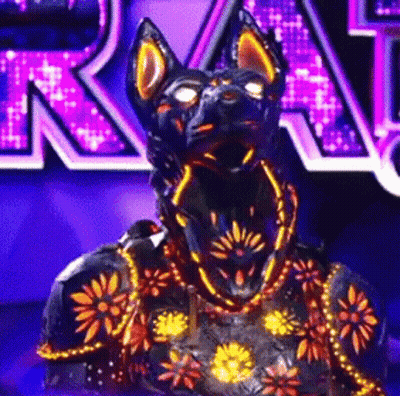 A Statue Of A Black Dog With Glowing Eyes And A Purple Background GIF