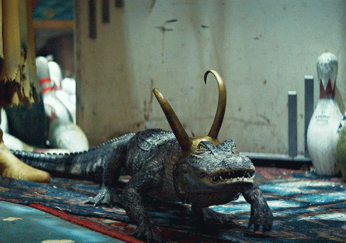 A Statue Of A Crocodile With A Crown On Its Head GIF