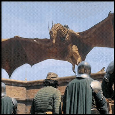 A Statue Of A Dragon Flying Over A Group Of People GIF