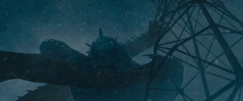 A Statue Of A Dragon Is Laying On The Ground In Front Of A Telephone Pole . GIF
