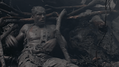 A Statue Of A Man Covered In Mud With The Word Jesus On His Chest GIF