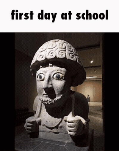 A Statue Of A Man Giving A Thumbs Up With The Words First Day At School Above It GIF