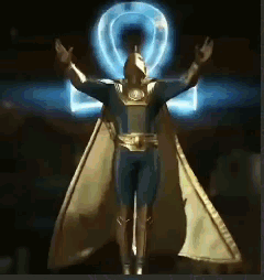 A Statue Of A Man In A Superhero Costume With His Arms Outstretched GIF