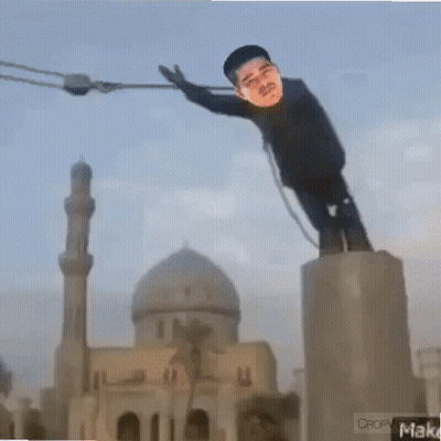 A Statue Of A Man Is Hanging From A Rope In Front Of A Mosque GIF