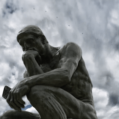 A Statue Of A Man Kneeling Down Thinking With A Cloudy Sky Behind Him GIF