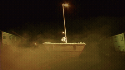 A Statue Of A Man Standing On Top Of A Dumpster GIF