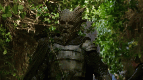 A Statue Of A Man With A Beard And A Tree Face GIF