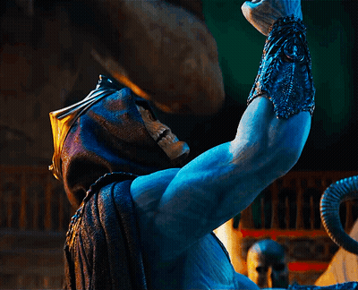 A Statue Of A Man With A Skull On His Face Is Holding Something In His Hand GIF