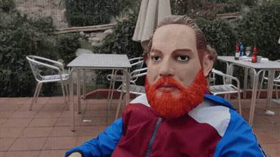 A Statue Of A Man With An Orange Beard Is Sitting In A Chair GIF