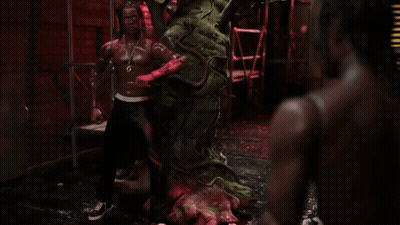 A Statue Of A Man With Dreadlocks And A Necklace That Says ' G ' On It GIF