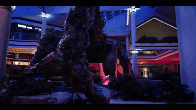 A Statue Of A Monster In A Mall With A Sign That Says ' A & R ' On It GIF