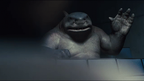 A Statue Of A Shark Waving Its Hand In The Dark GIF