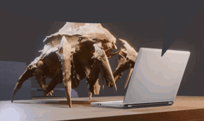 A Statue Of A Spider Looking At A Laptop GIF