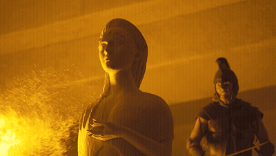 A Statue Of A Woman Standing Next To A Man GIF