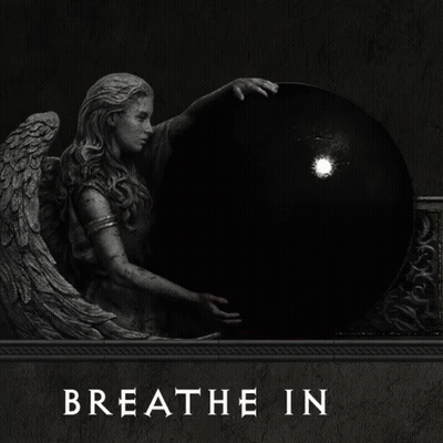 a statue of an angel holding a red ball with the words breathe out underneath it