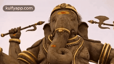 A Statue Of An Elephant Holding A Trident And An Arrow GIF