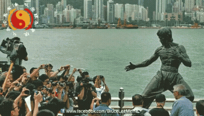 A Statue Of Bruce Lee Is Surrounded By People Taking Pictures GIF