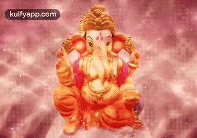 A Statue Of Ganesha Is Sitting On A Pink Surface . GIF