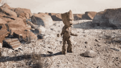 A Statue Of Groot Is Standing In A Desert GIF
