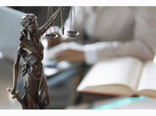 A Statue Of Lady Justice With Scales And A Sword GIF