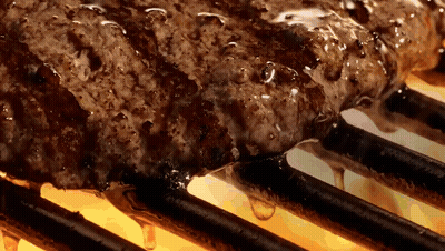 A Steak Is Cooking On A Grill With A Lot Of Liquid Dripping Off Of It GIF