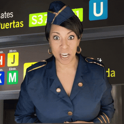 A Stewardess Stands In Front Of A Sign That Says Gates Puertas GIF
