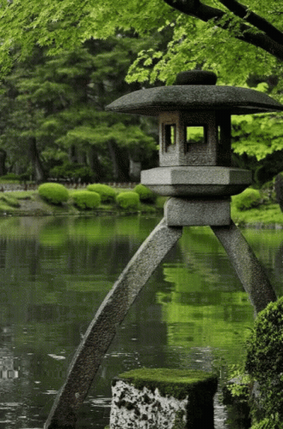 A Stone Lantern Sits In The Middle Of A Pond With Trees In The Background GIF
