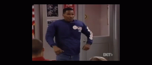 A Stop Sign Is In The Middle Of A Classroom With People Sitting At Desks . GIF
