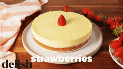 A Strawberry Cheesecake On A White Plate With The Words Delish Strawberries GIF