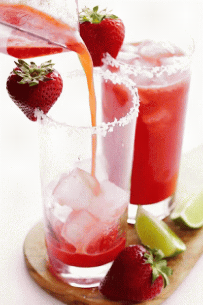 A Strawberry Margarita Being Poured Into A Glass With Ice GIF
