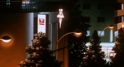 A Street Light Is Lit Up In Front Of A Building With The Letter K On It GIF