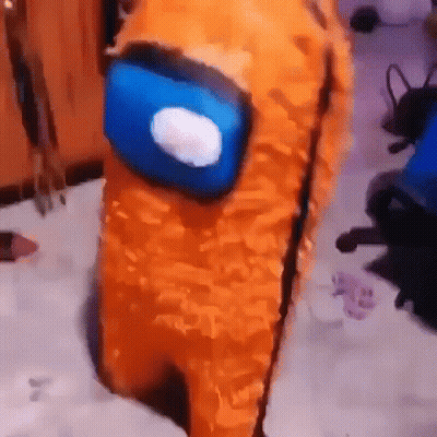 A Stuffed Animal Dressed As An Orange Among Us Character With A Blue Head . GIF