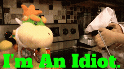 A Stuffed Animal In A Kitchen With The Words " I 'M An Idiot " Above It GIF