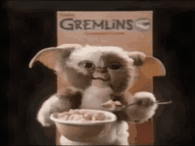 A Stuffed Animal Is Holding A Bowl Of Cereal . GIF